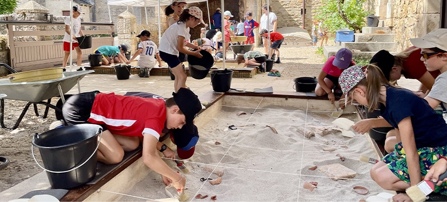Jeunes enfants qui réalisent une fouille archéologique 